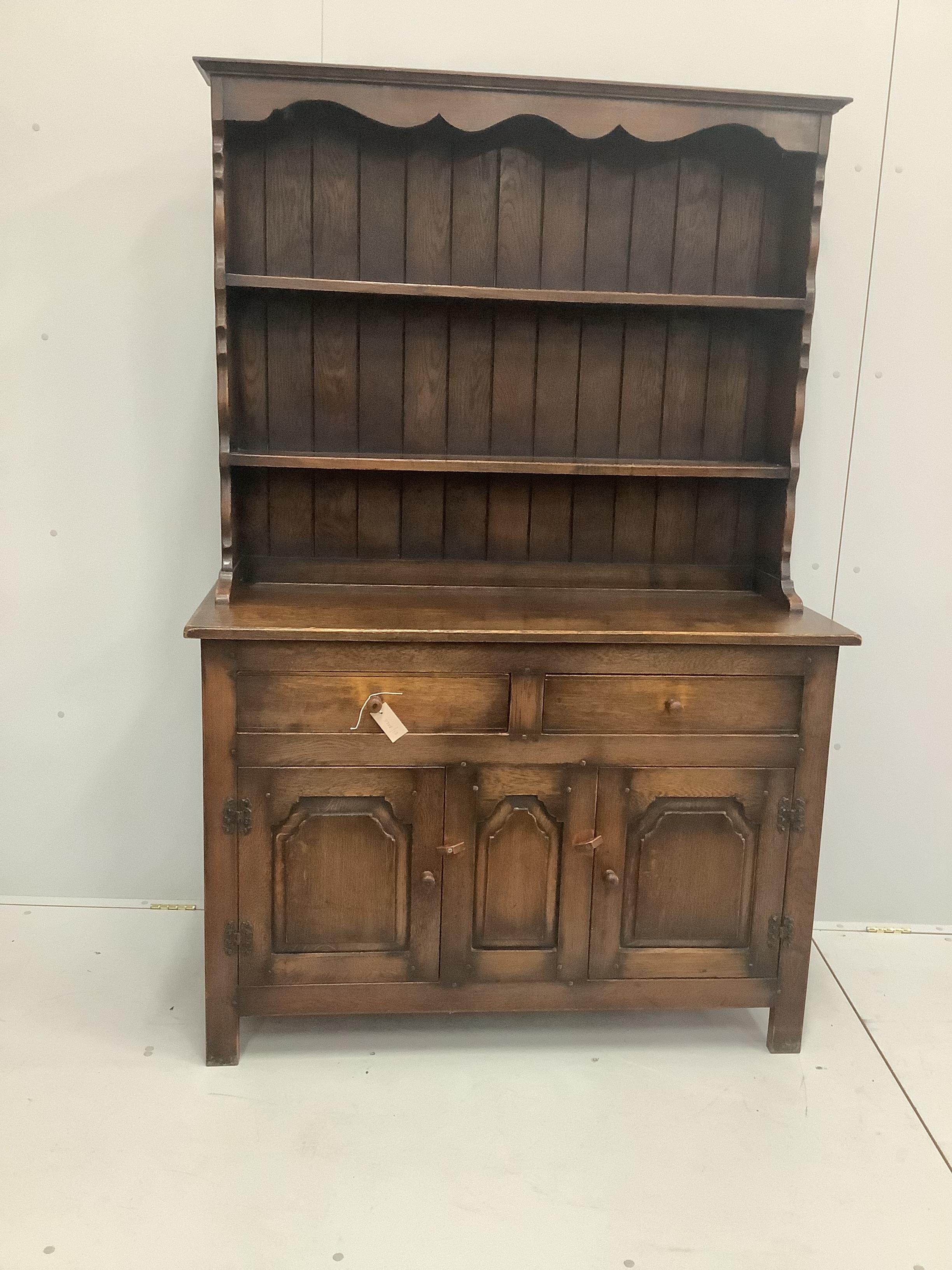 A 1920's oak dresser with boarded rack, width 122cm, depth 46cm, height 183cm.